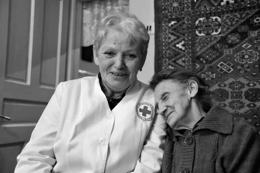 Pflegerin des Roten Kreuzes und eine alte Frau, Kopf an Kopf