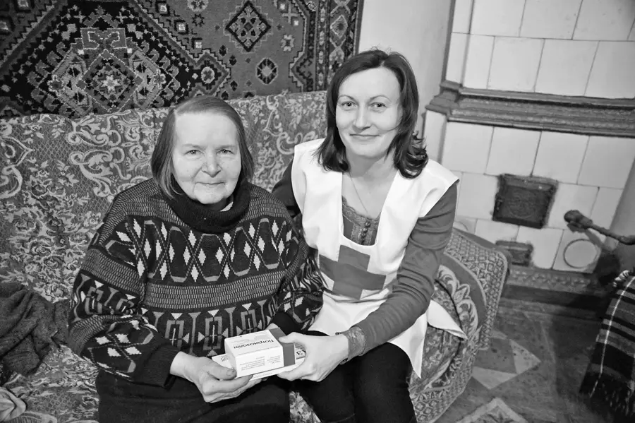 Pflegerin und Seniorin auf dem Sofa