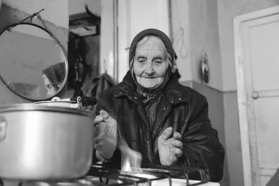 Alte Frau kocht in ihrer Wohnung