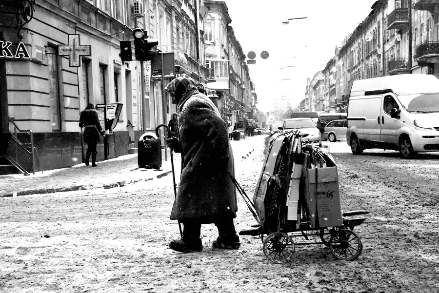 Alte Frau mit Handwagen auf einer Straße in Lwiw